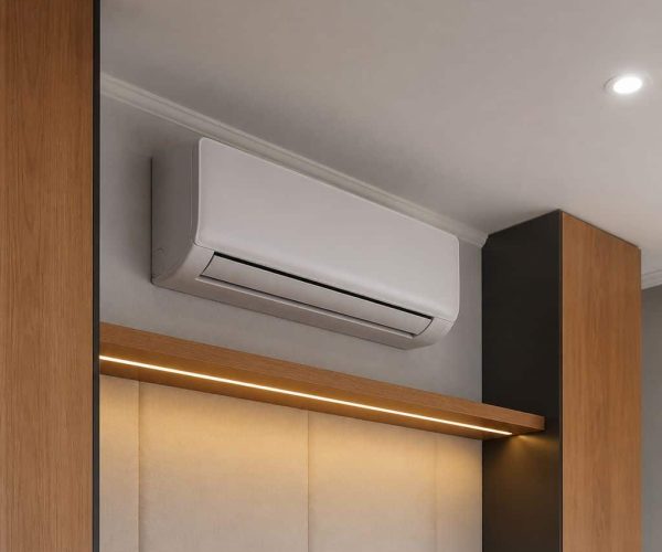 White ductless mini split air handler wall-mounted between warm wood panels with recessed lighting and LED strip in a modern interior room